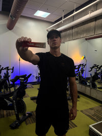 Alex S. holding a Tune stick pack in a cycling studio