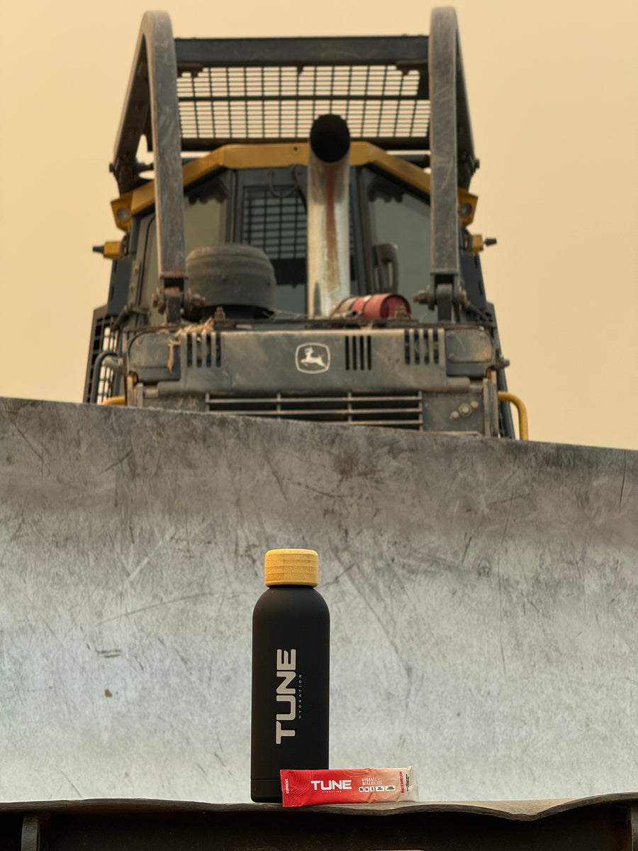 Tune bottle and Watermelon stick on a bulldozer blade at a job site