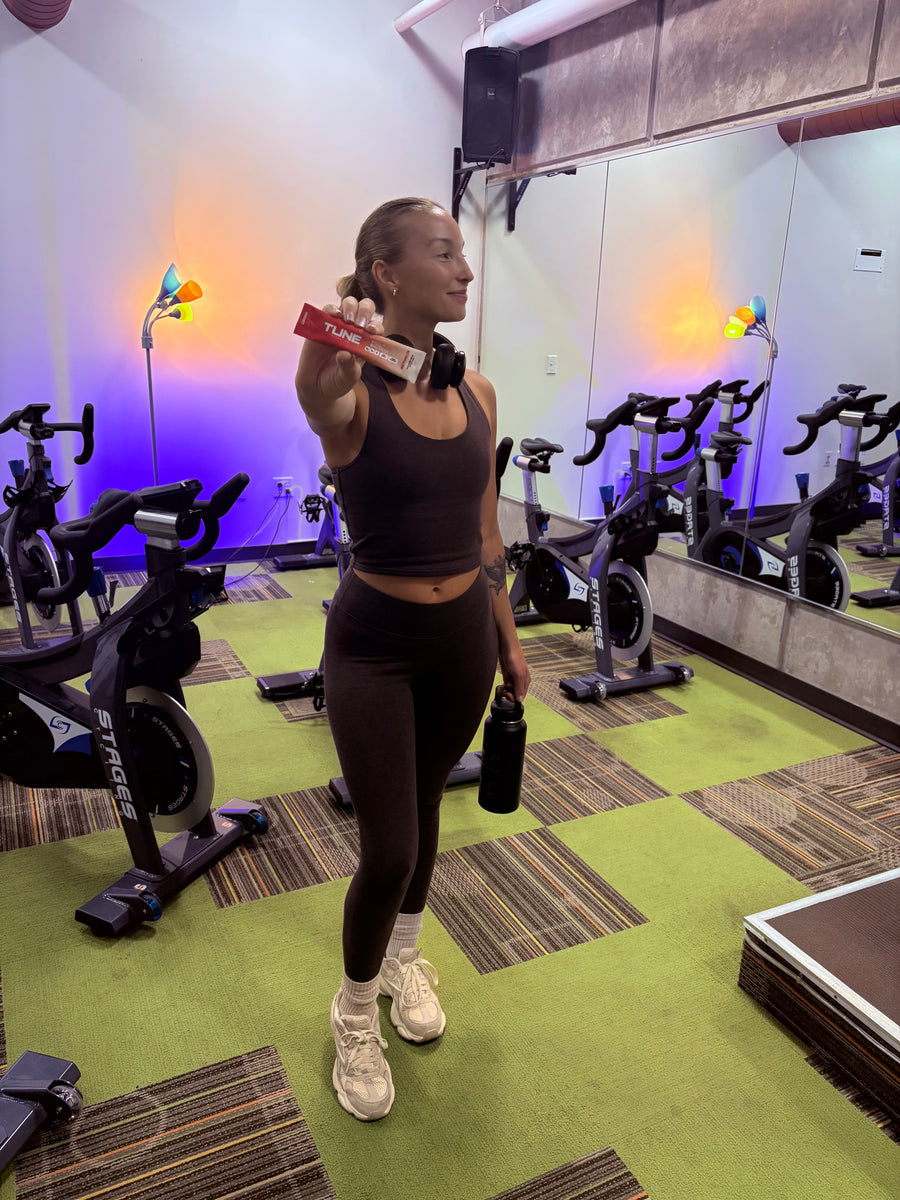 Rider holding a Tune Watermelon stick in a spin studio